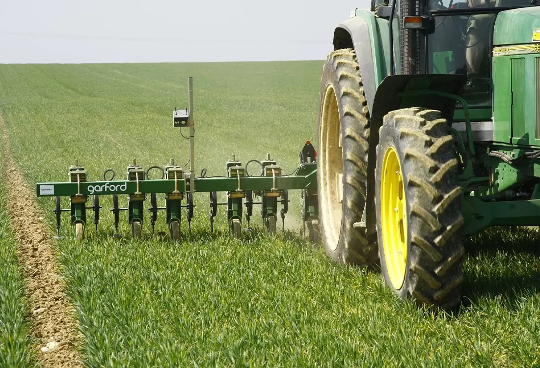 Garford Maschine hinter Traktor auf dem grünen Feld